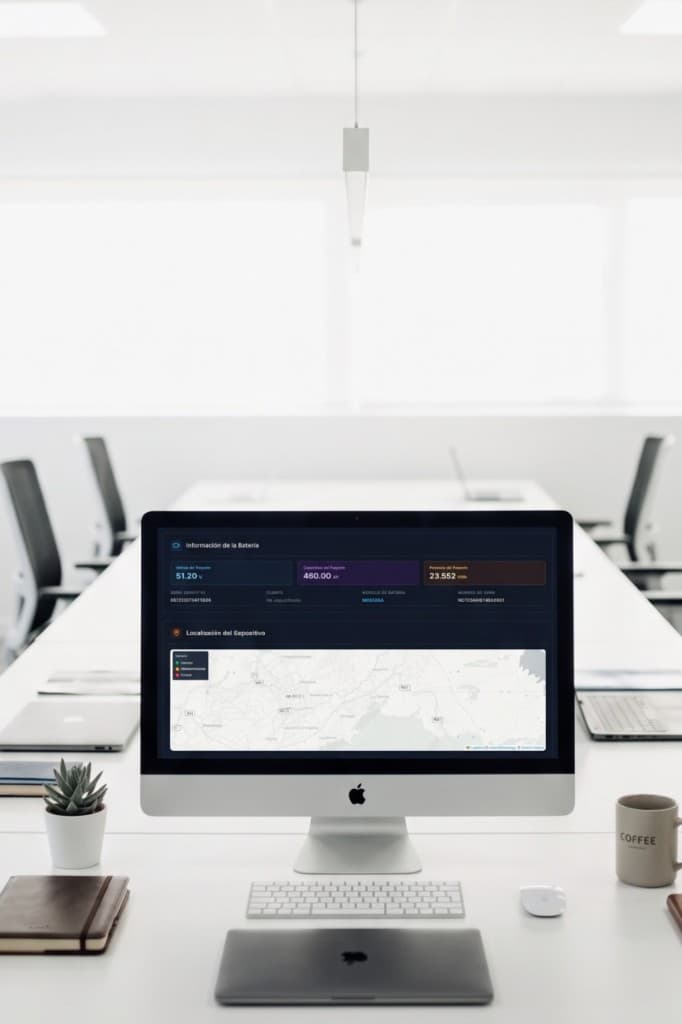 Panel de cloud data en monitor de escritorio con métricas de batería y mapa de localización